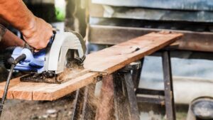 worker cutting wood with a circular saw