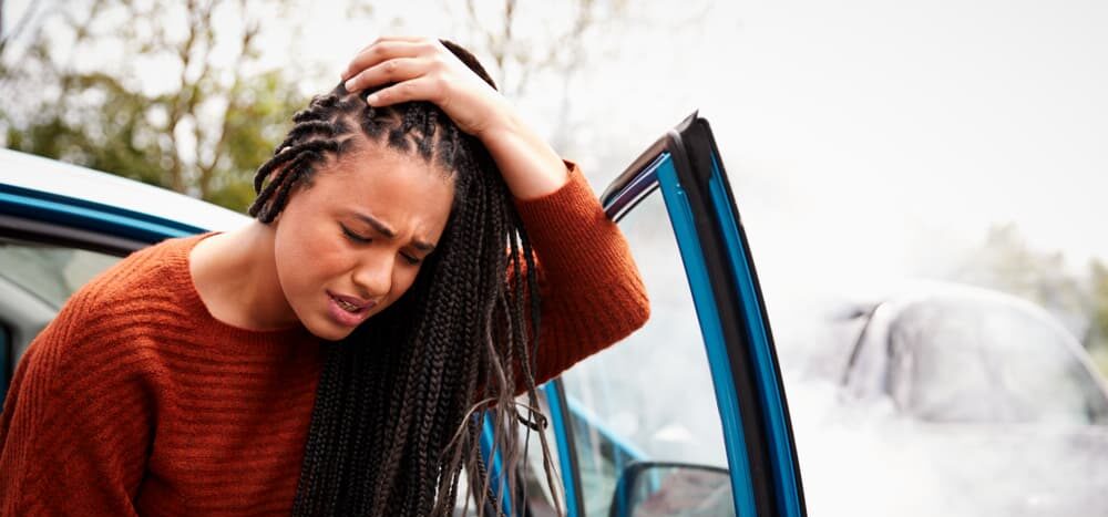 women holding head in pain after being involved in a car crash