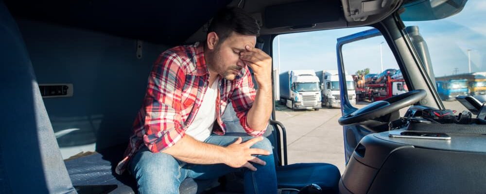 hurt trucker sitting at rest stop; call a workers comp trucker advocate lawyer today!