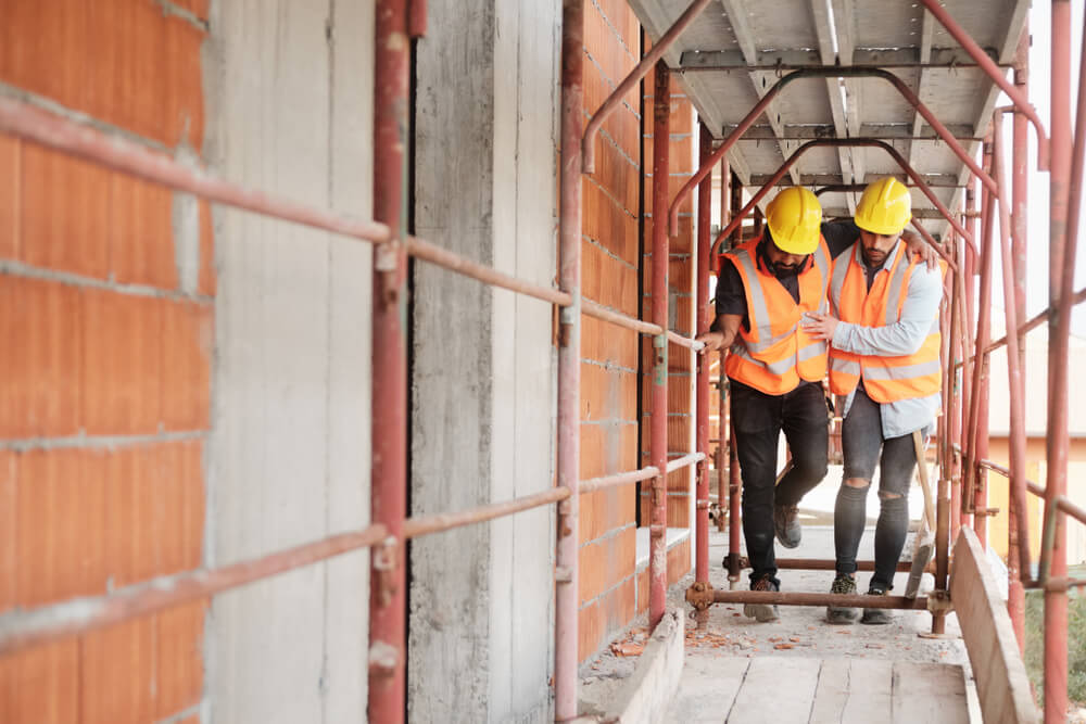 People working in construction site. Young men at work in new house inside apartment building.
