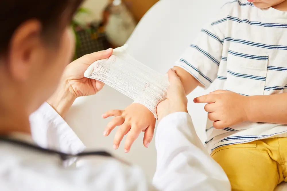 doctor wraps bandage around child's wrist