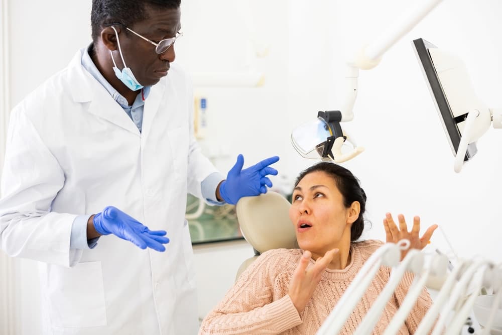 woman talking to confused dentist after dental treatment