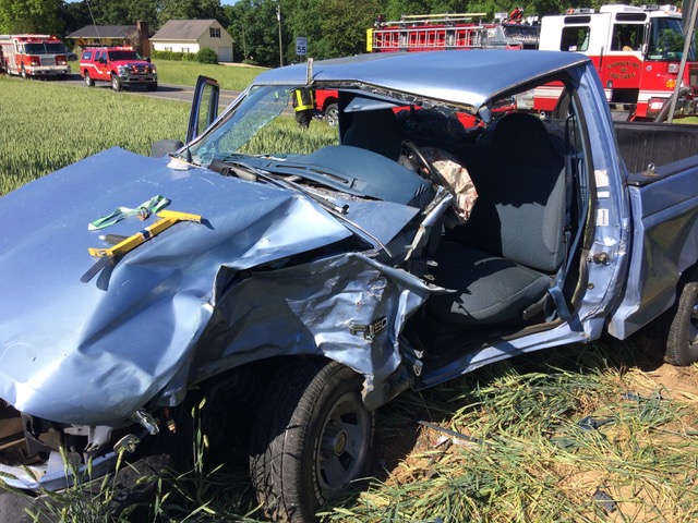 total body damage to blue pickup truck after crash