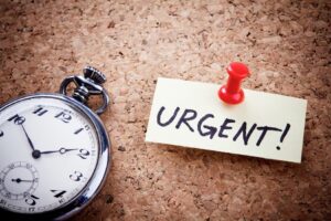 post it with urgent written down next to a stopwatch